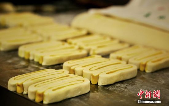 圖為面劑被涂上胡麻油，切成條狀用作月餅的花型制作。張文 攝