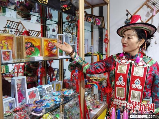 圖為身著民族服飾的隴原巧手展示手工藝品。(資料圖) 徐雪 攝