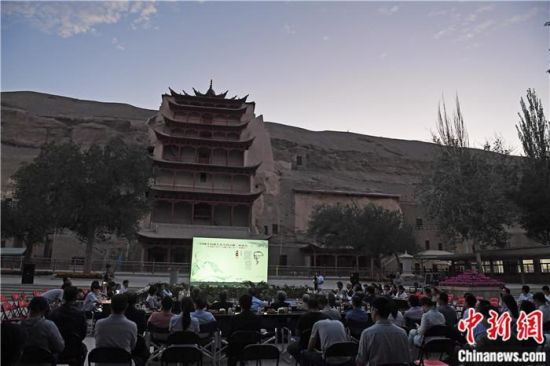 2018年8月，在敦煌莫高窟標(biāo)志性建筑“九層樓”前，《回顧平山郁夫先生的貢獻(xiàn)》座談會(huì)舉行。來(lái)自中日兩國(guó)的專家、學(xué)者共同懷念這位情系敦煌數(shù)十載的繪畫巨匠、中日友好的文化使者、世界文化遺產(chǎn)的守護(hù)者。中新社記者 楊艷敏 攝