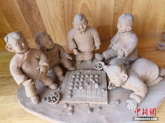 圖為泥塑作品展現(xiàn)下棋場(chǎng)景。 劉玉桃 攝