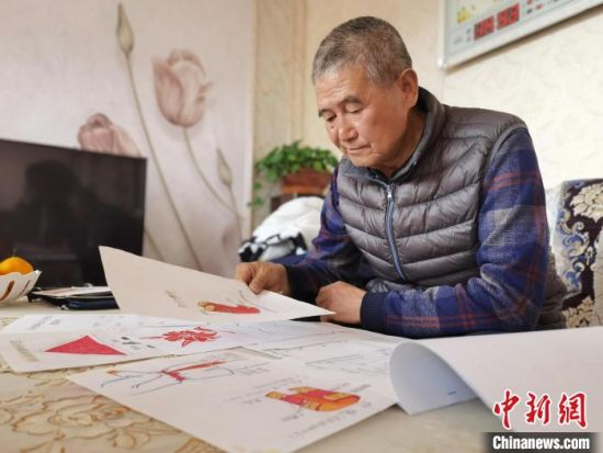 圖為陸鵬飛向記者展示多年帶隊(duì)的手寫筆記?！堟?攝