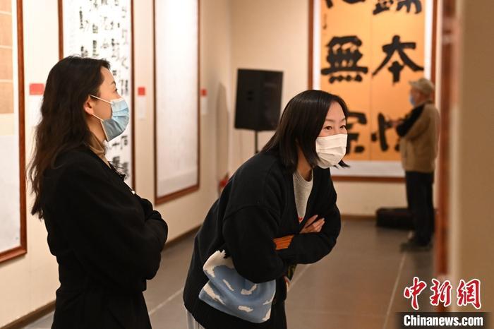 圖為甘肅蘭州，參展書(shū)法作品吸引參觀者。 中新社記者 李亞龍 攝