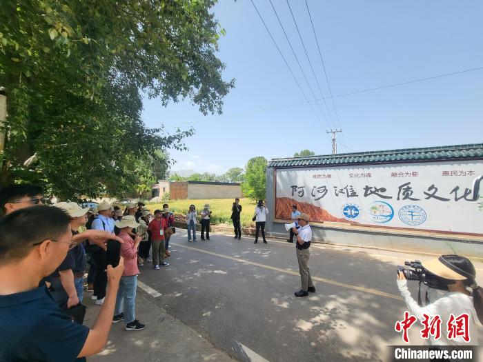 圖為中國地質(zhì)大學(xué)(北京)教授張緒教介紹村落情況?！『衍?攝