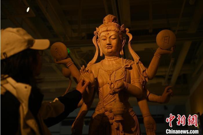 圖為季茂杰觀察自己創(chuàng)作的敦煌木雕。李亞龍 攝</p>
<p>