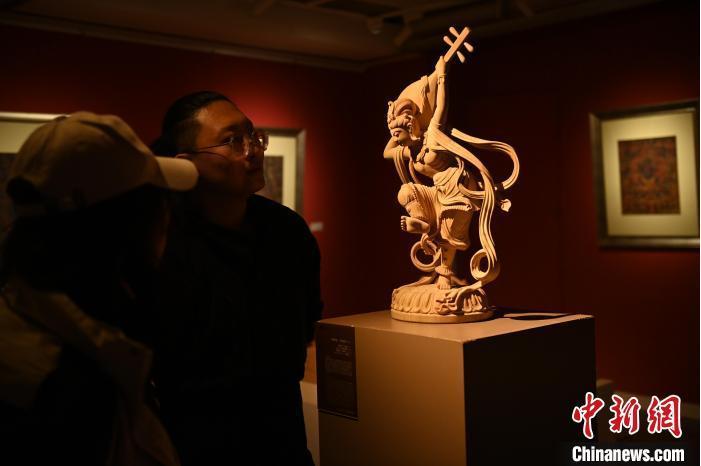 圖為季茂杰向參觀者介紹自己創(chuàng)作敦煌木雕的過程。李亞龍 攝</p>
<p>