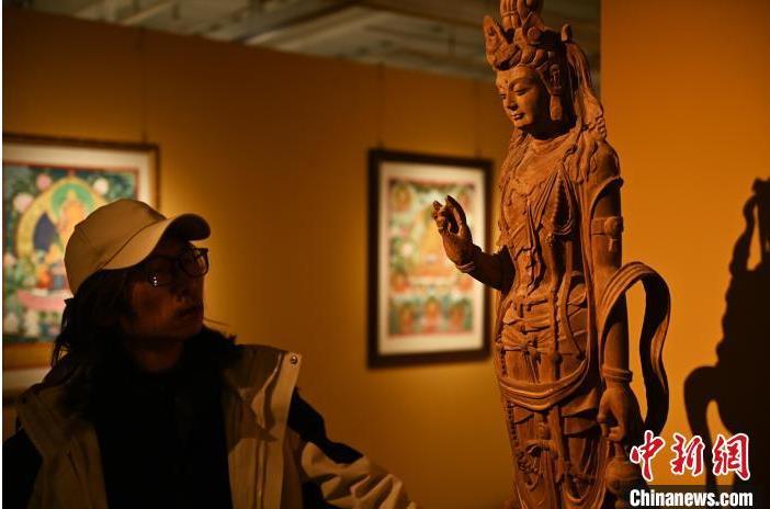 圖為季茂杰觀察自己創(chuàng)作的敦煌木雕。李亞龍 攝</p>
<p>