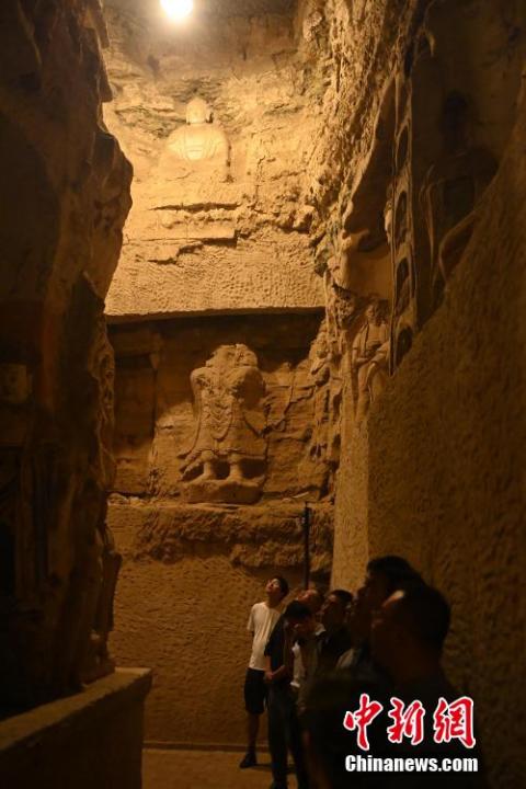 7月15日，游人參觀甘肅省平?jīng)鍪袥艽h百里石窟長廊中的王母宮石窟。百里石窟長廊位于涇川縣境內(nèi)，由512個石窟、5眼窟中石井組成，現(xiàn)存王母宮石窟、鳳凰山石窟、南石窟寺、丈八寺石窟、羅漢洞石窟、太山寺石窟等規(guī)模較大的石窟群，還有數(shù)量眾多的小石窟群。王母宮石窟又名千佛洞，該窟設計宏大，造像生動，窟內(nèi)擁有造像數(shù)百尊，是較為珍貴的佛教文化遺存。中新社記者 李亞龍 攝</p>
<p>
